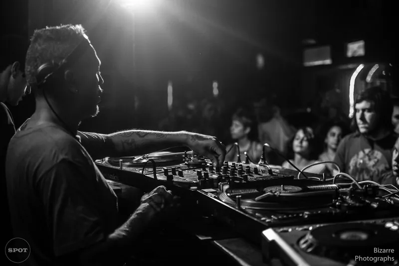DJ Koolt mezclando con bandejas frente al público en The Spot, en blanco y negro