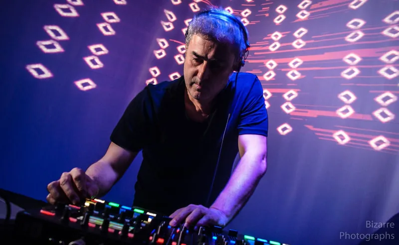 DJ mezclando frente a una pantalla con visuales de rombos rojos en The Spot