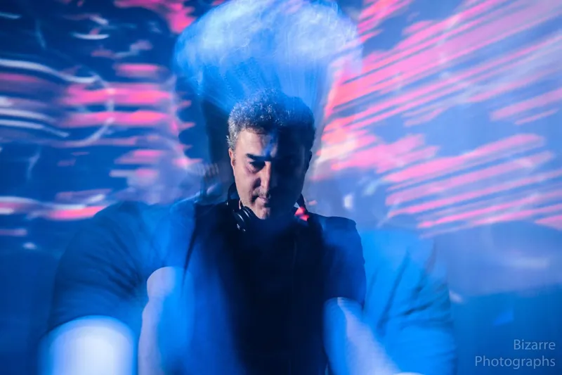 DJ en movimiento bajo luces azules y rojas en The Spot